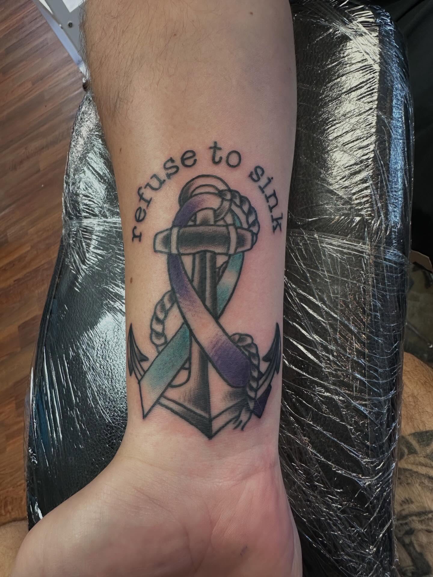 Anchor with ribbon black and grey tattoo on the forearm by Zach Eden