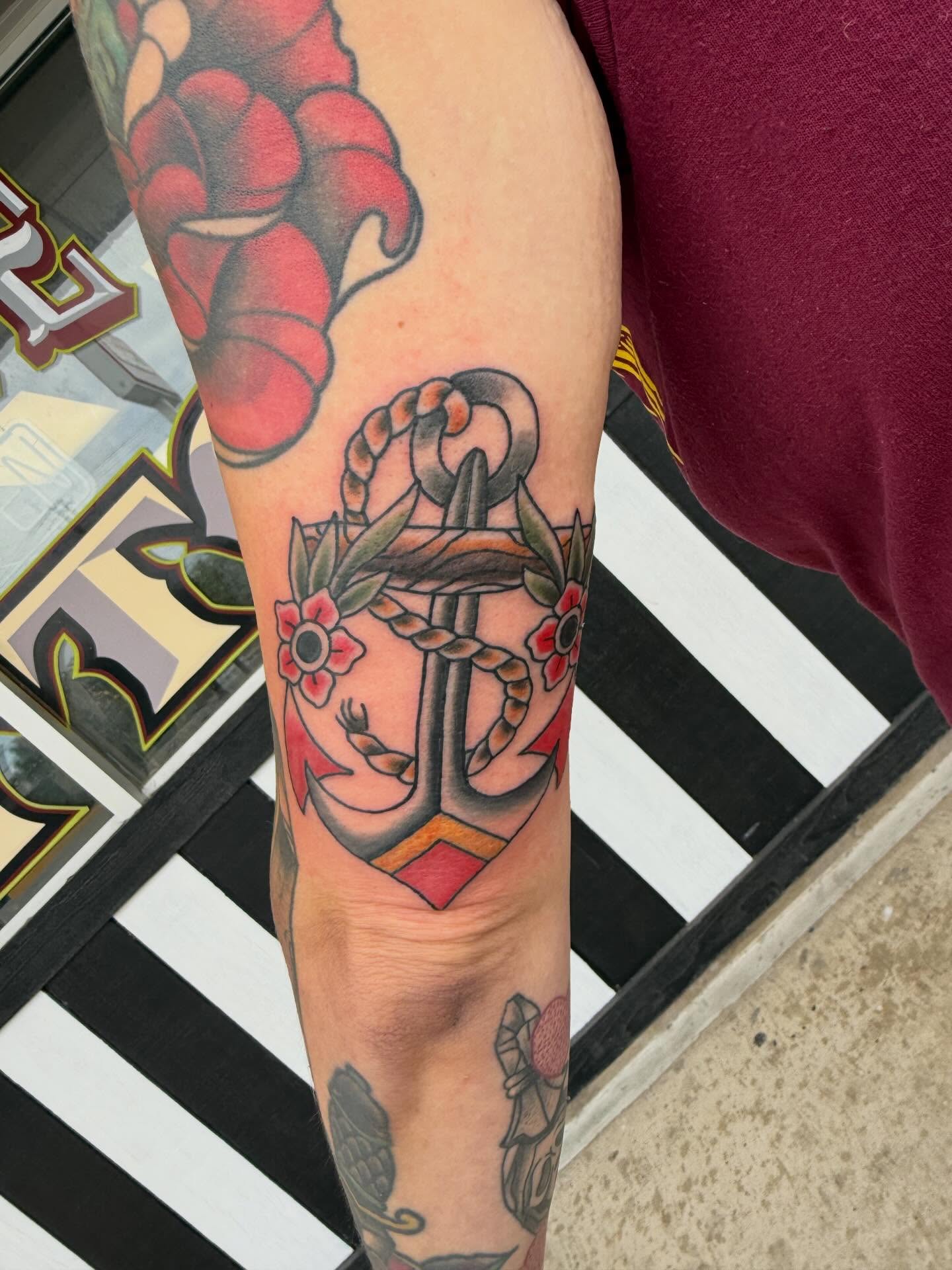 Anchor with flowers American traditional tattoo on the forearm by Zach Eden