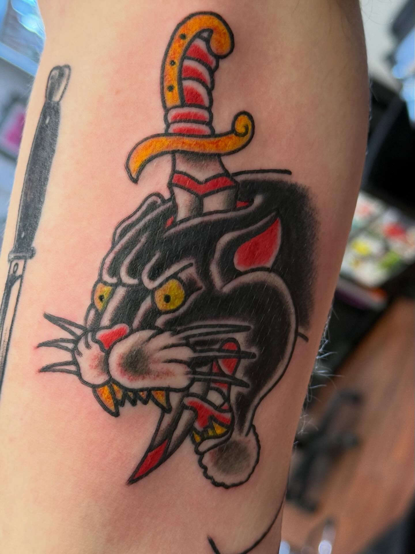 Panther with dagger American traditional tattoo on the forearm by Zach Eden