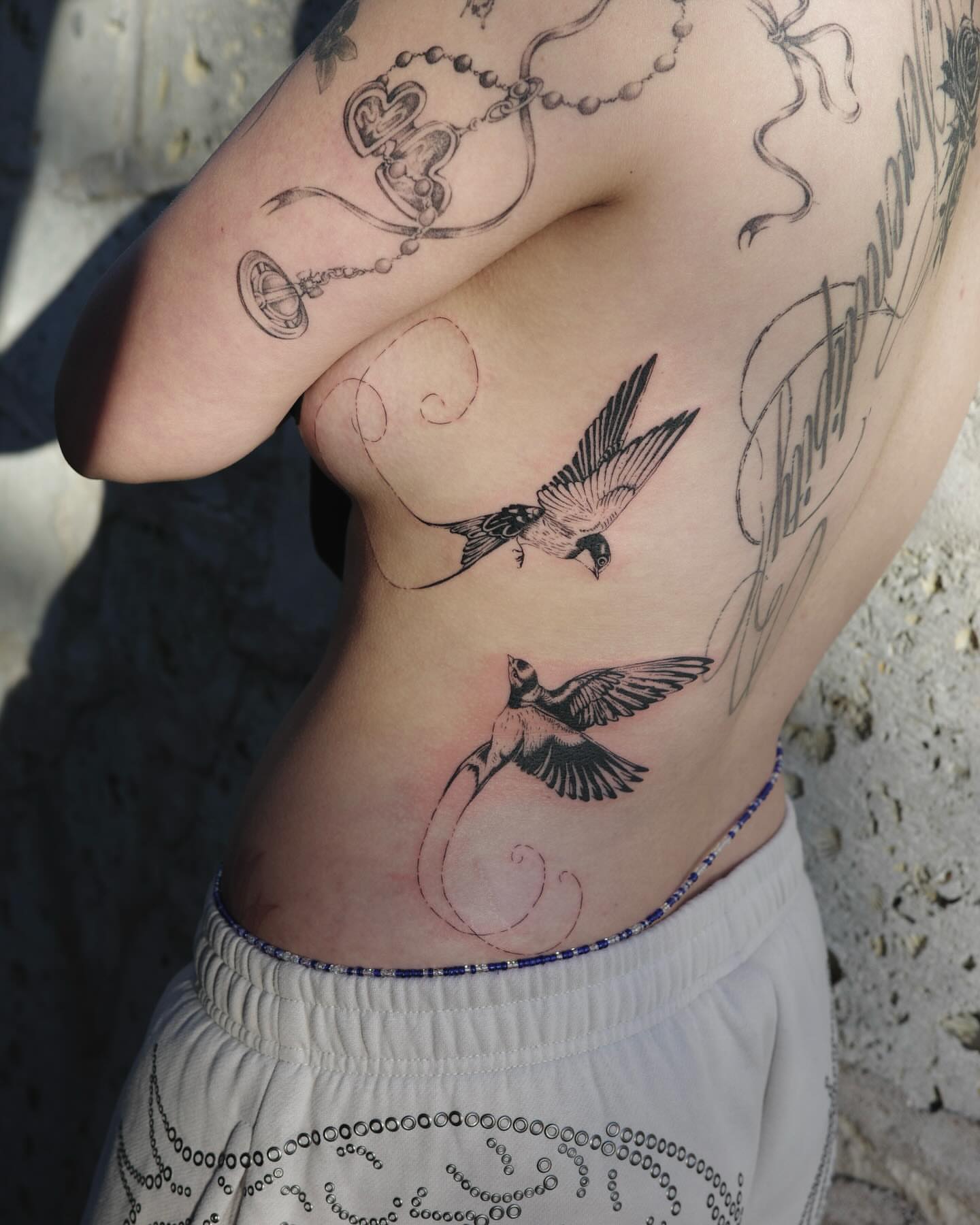 Birds black and grey tattoo on the ribs by Sophia Tattoo