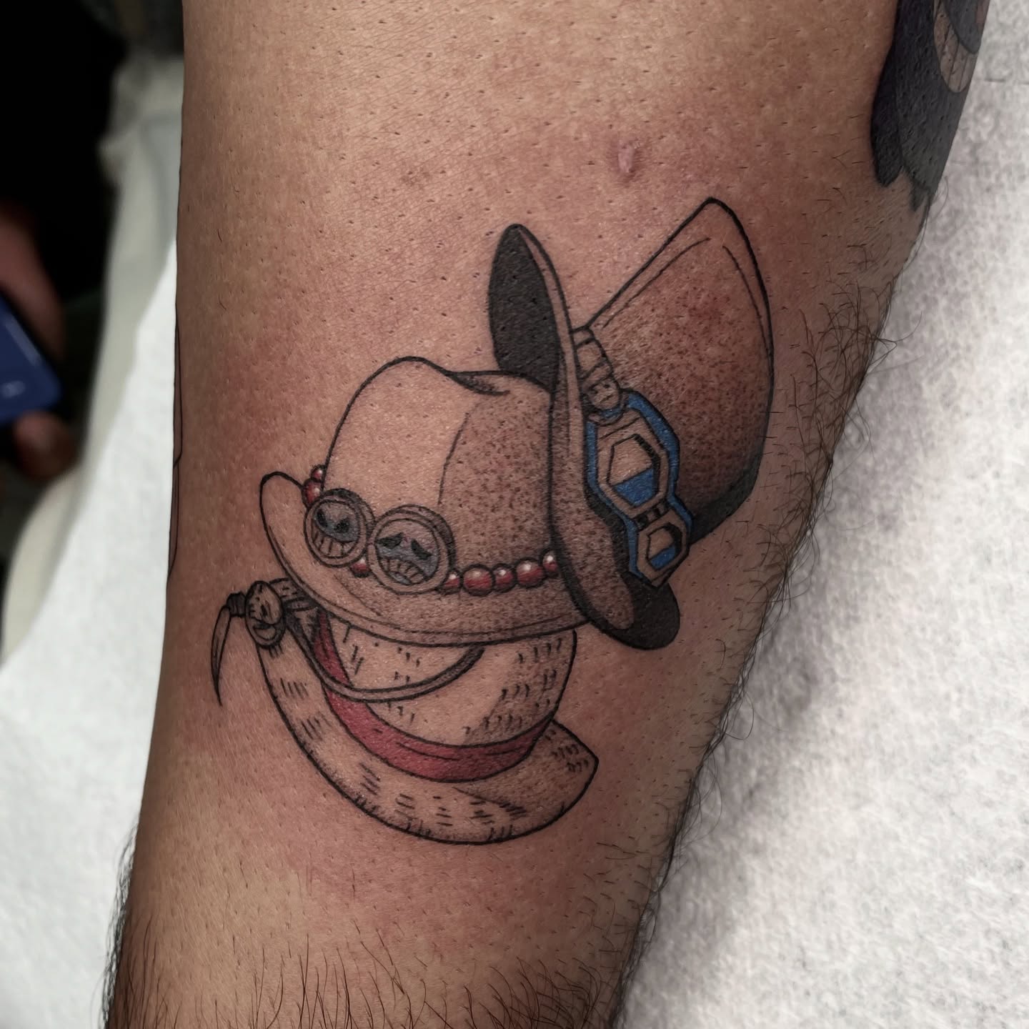 Hat with goggles realism tattoo on the forearm by Ducky