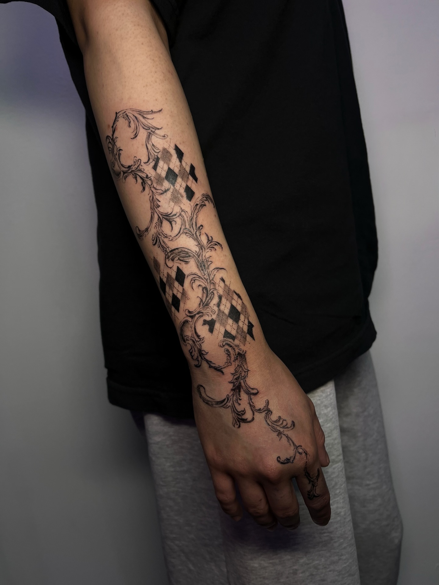 Checkered pattern black and grey tattoo on the forearm by MK