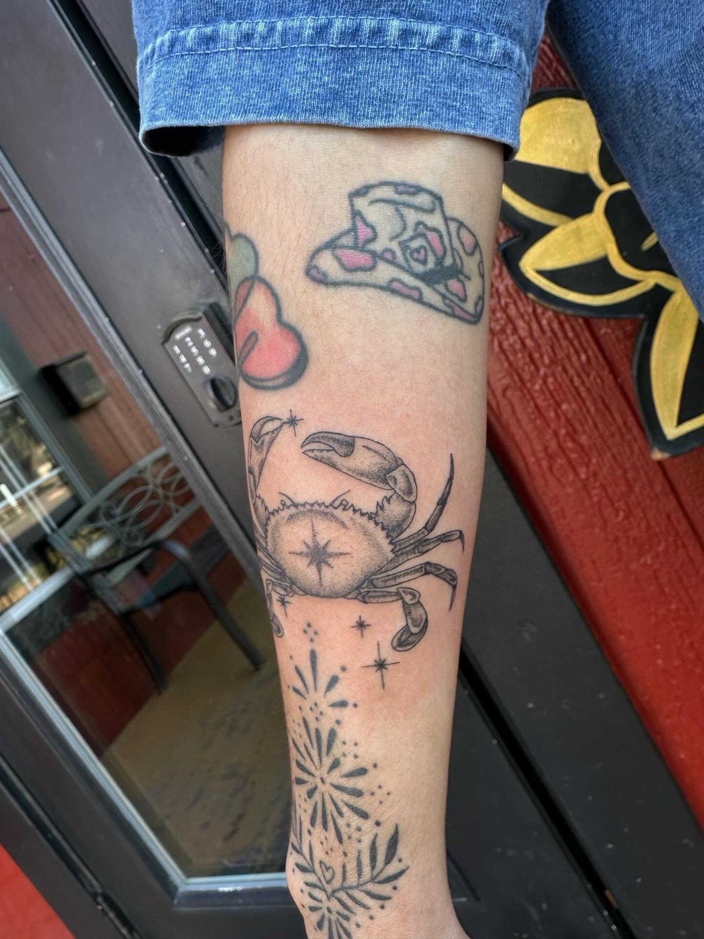 Crab and pizza slice black and grey tattoo on the forearm by J Valentin
