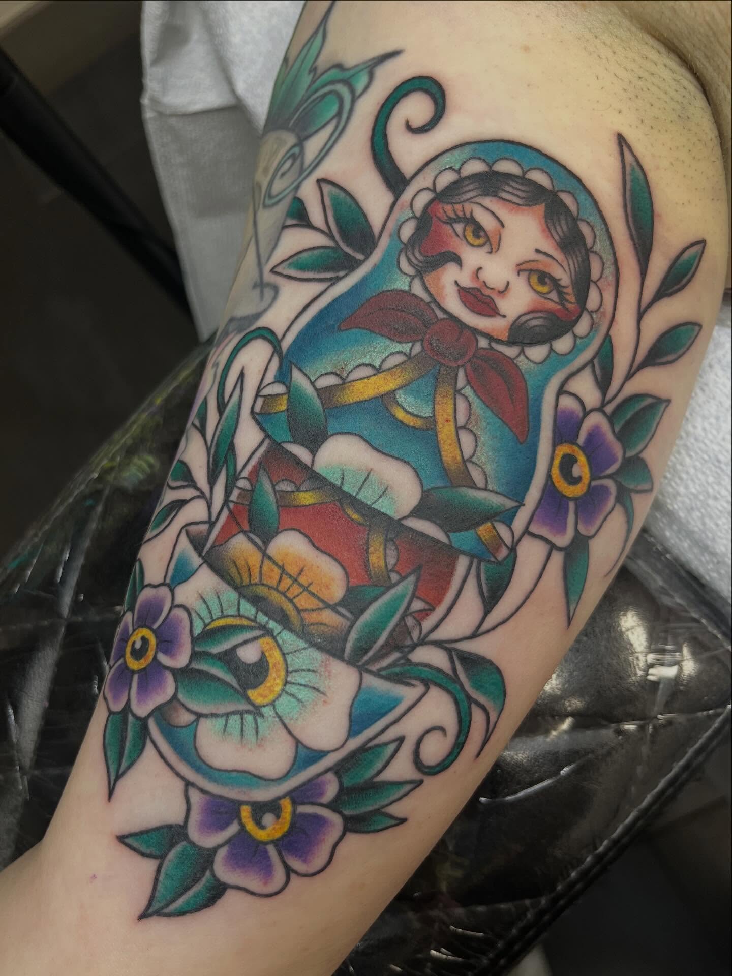 Doll with floral background American traditional tattoo on the forearm by Allie Tippets, Gilbert, Arizona