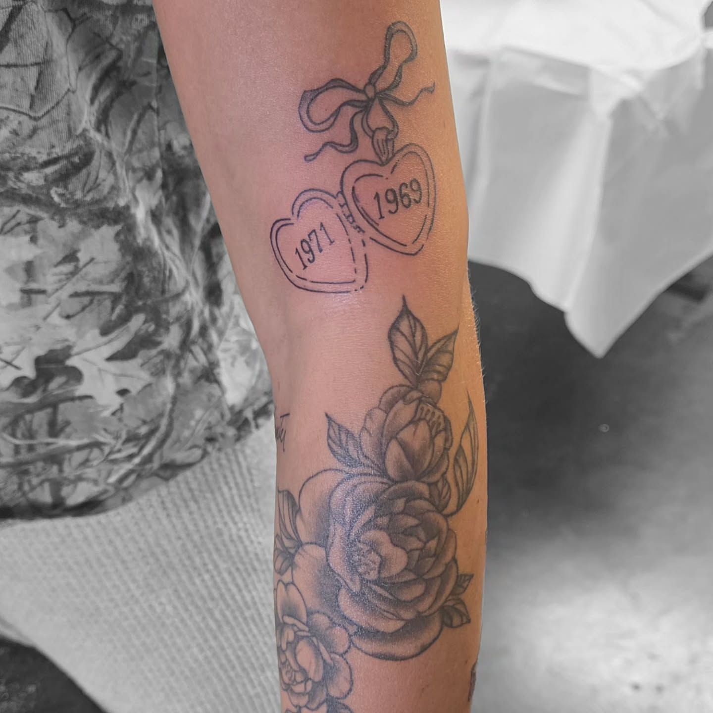 Hearts and roses black and grey tattoo on the forearm by Kat Coniglio Art