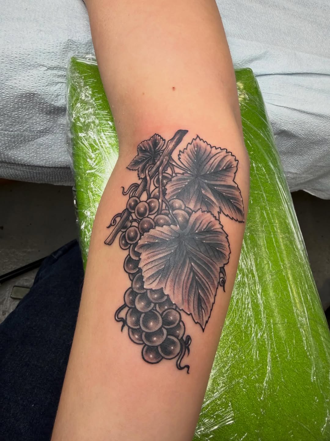 Bunch of grapes and leaves surrealism tattoo on the forearm by Joseph Kuma Warren, Memphis, Tennessee