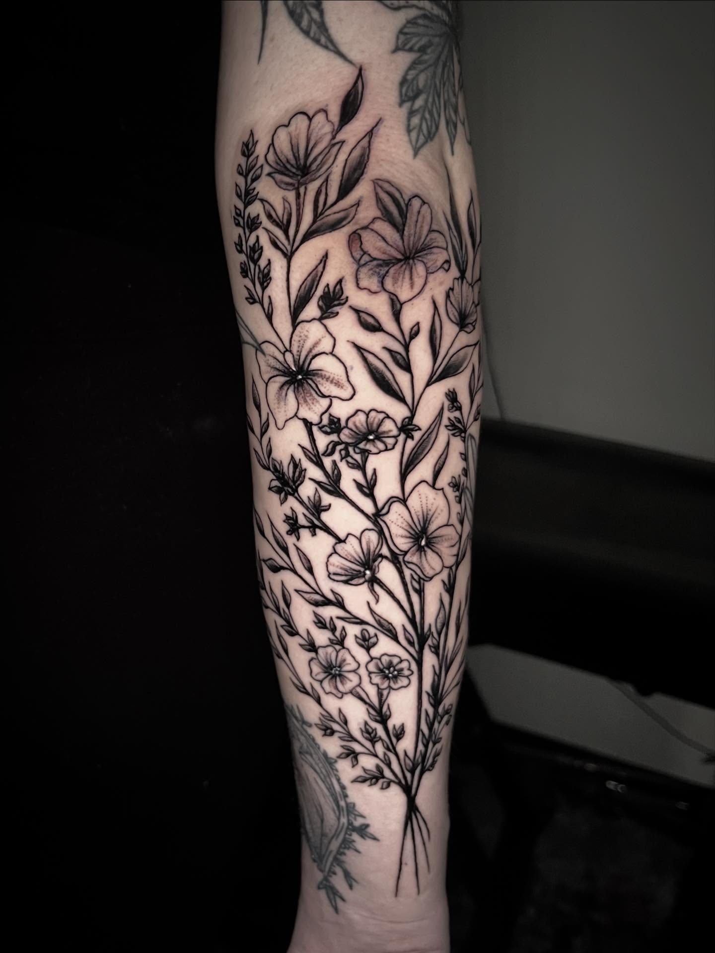 Floral arrangement black and grey tattoo on the forearm by Sean Gallagher