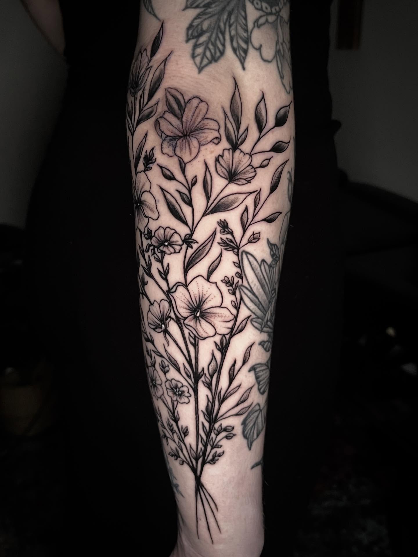 Floral bouquet black and grey tattoo on the forearm by Sean Gallagher
