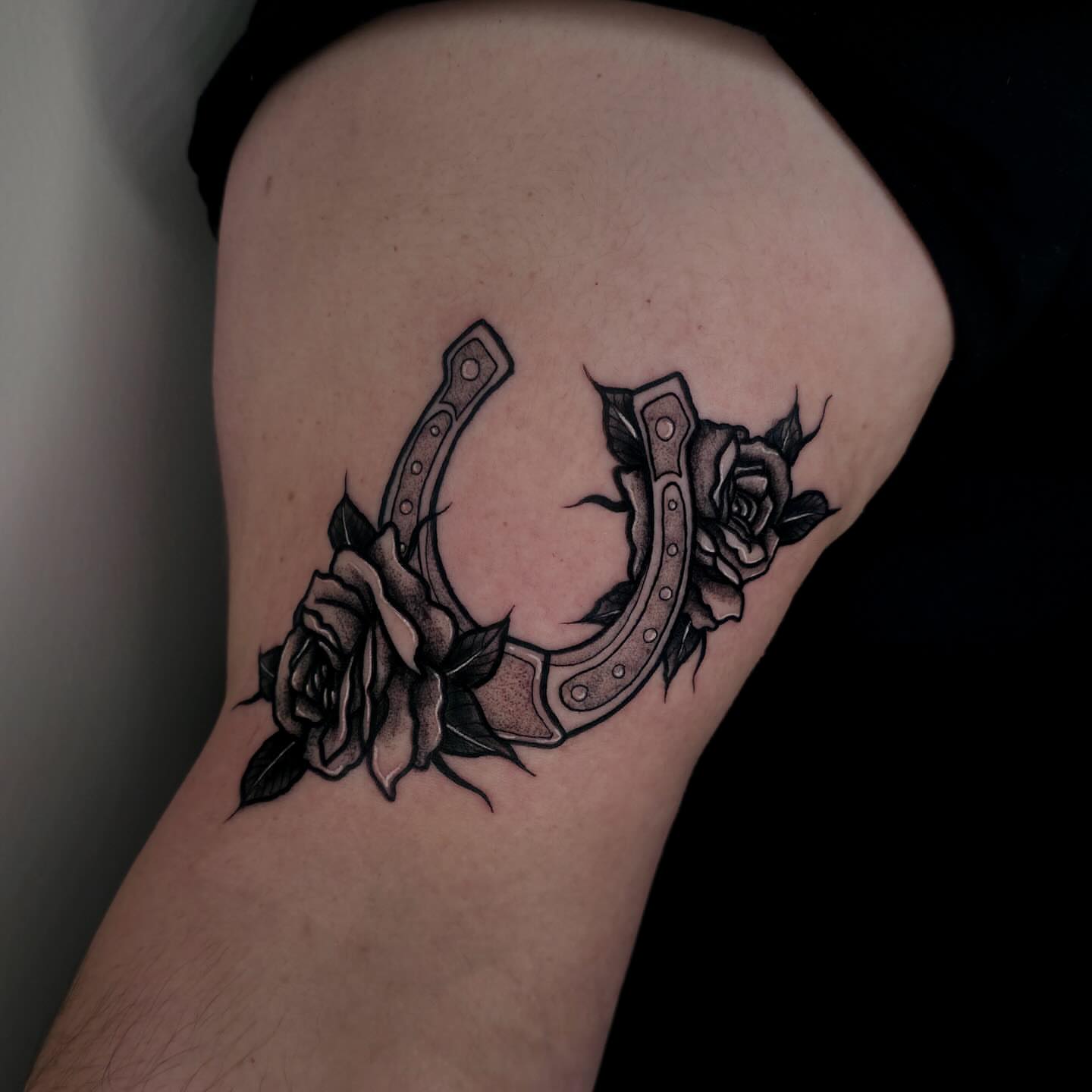 Horseshoe and roses black and grey tattoo on the thigh by ☻ Addie