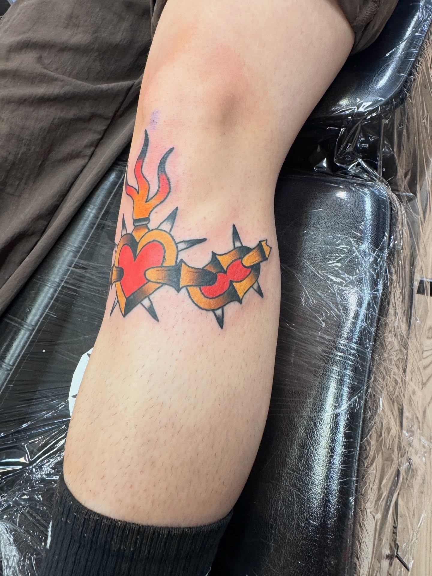 Heart with flames and spikes American traditional tattoo on the forearm by Justin Chapman, Des Moines, Iowa