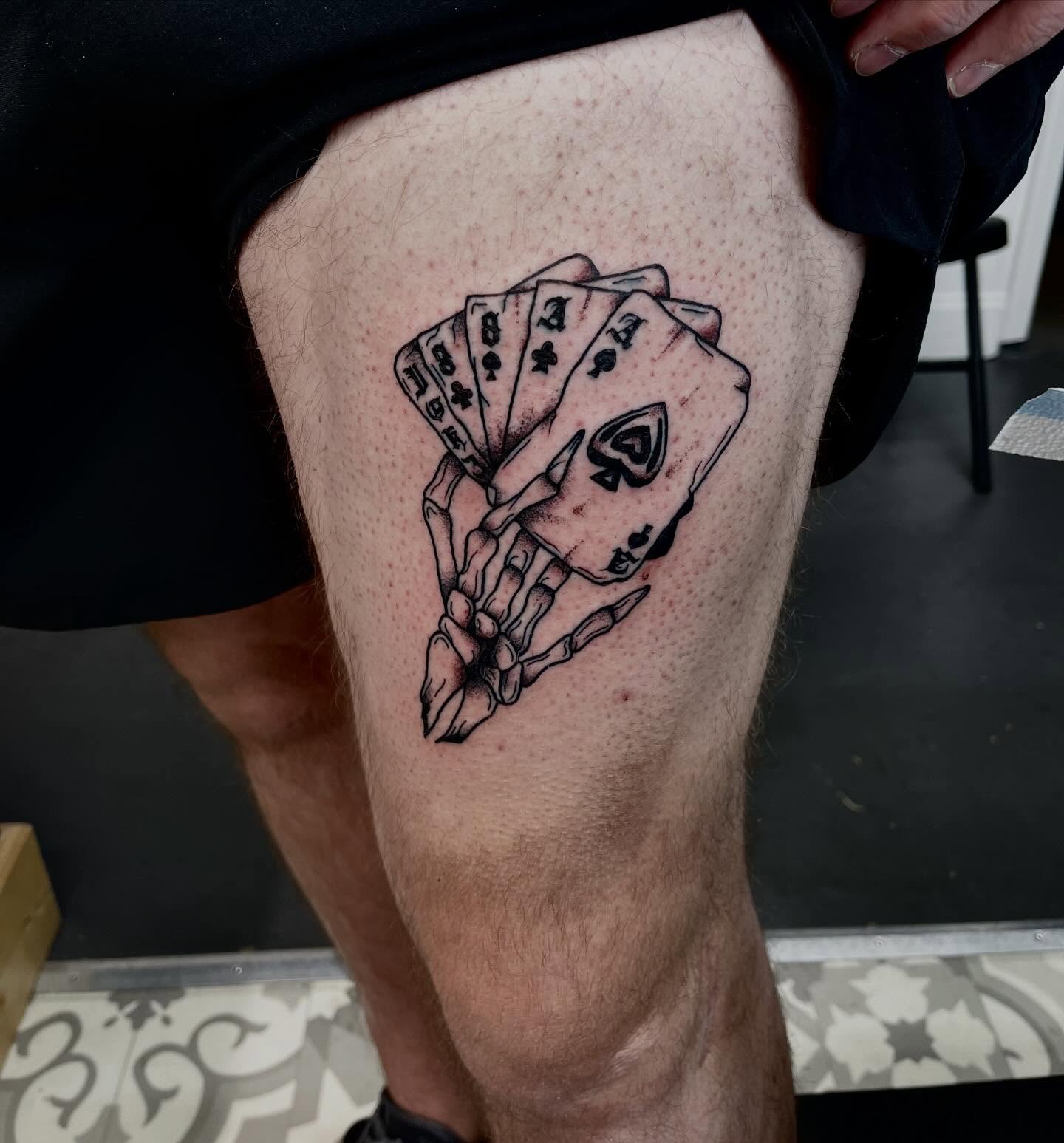 Playing cards black and grey tattoo on the thigh by Mason McCubbin