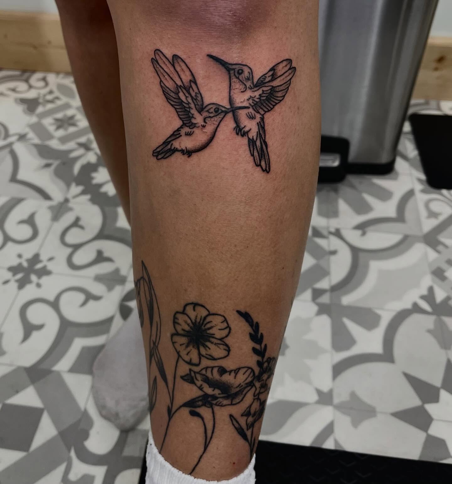 Hummingbirds and flowers black and grey tattoo on the calf by Mason McCubbin