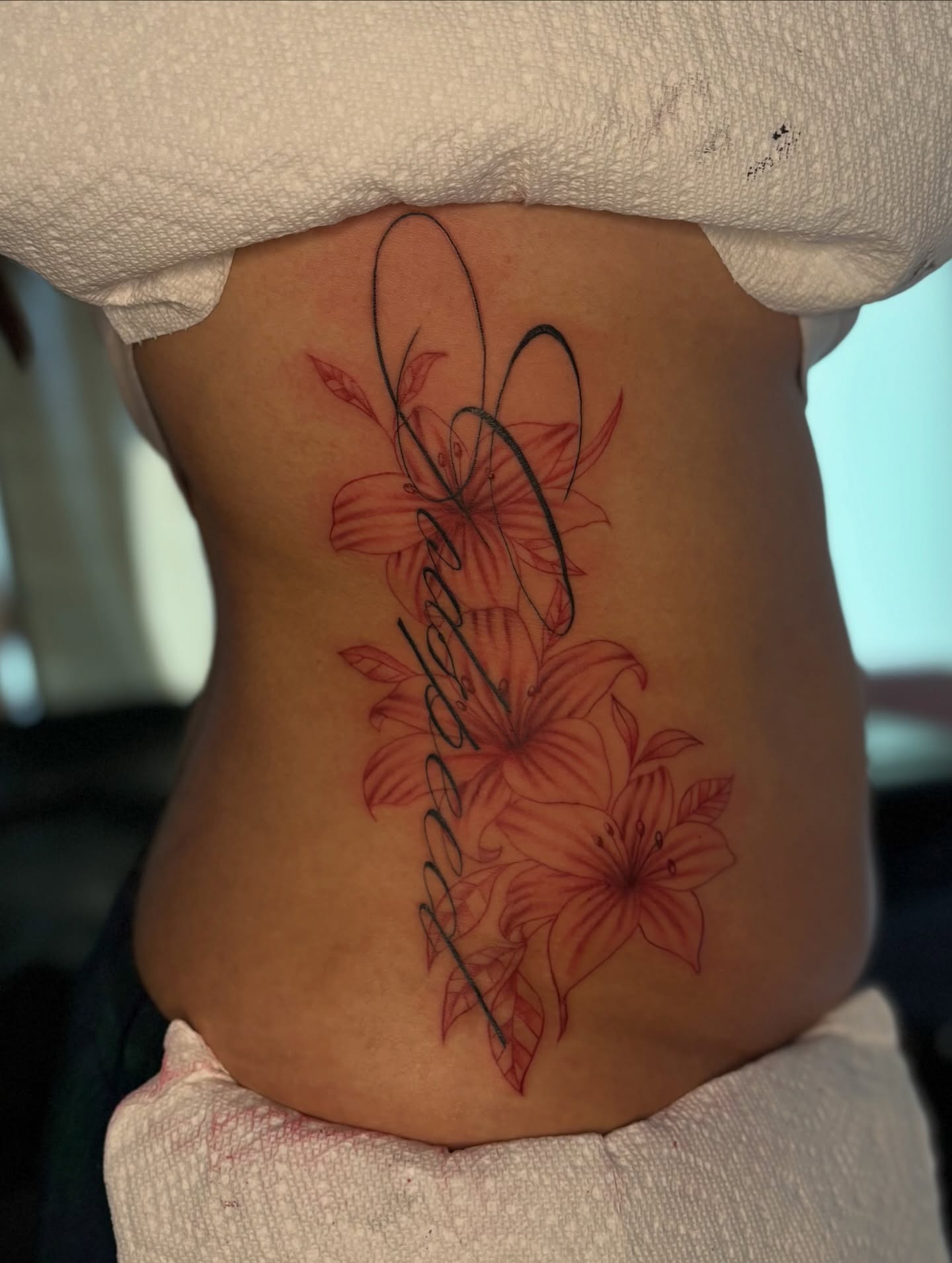 Lilies fine line tattoo on the torso by the ink witch ๐ฎ๐ค๐