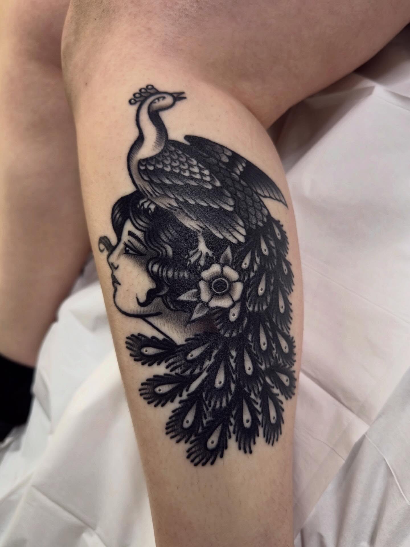 Peacock and woman realism tattoo on the thigh by Trav, Bayville, New Jersey