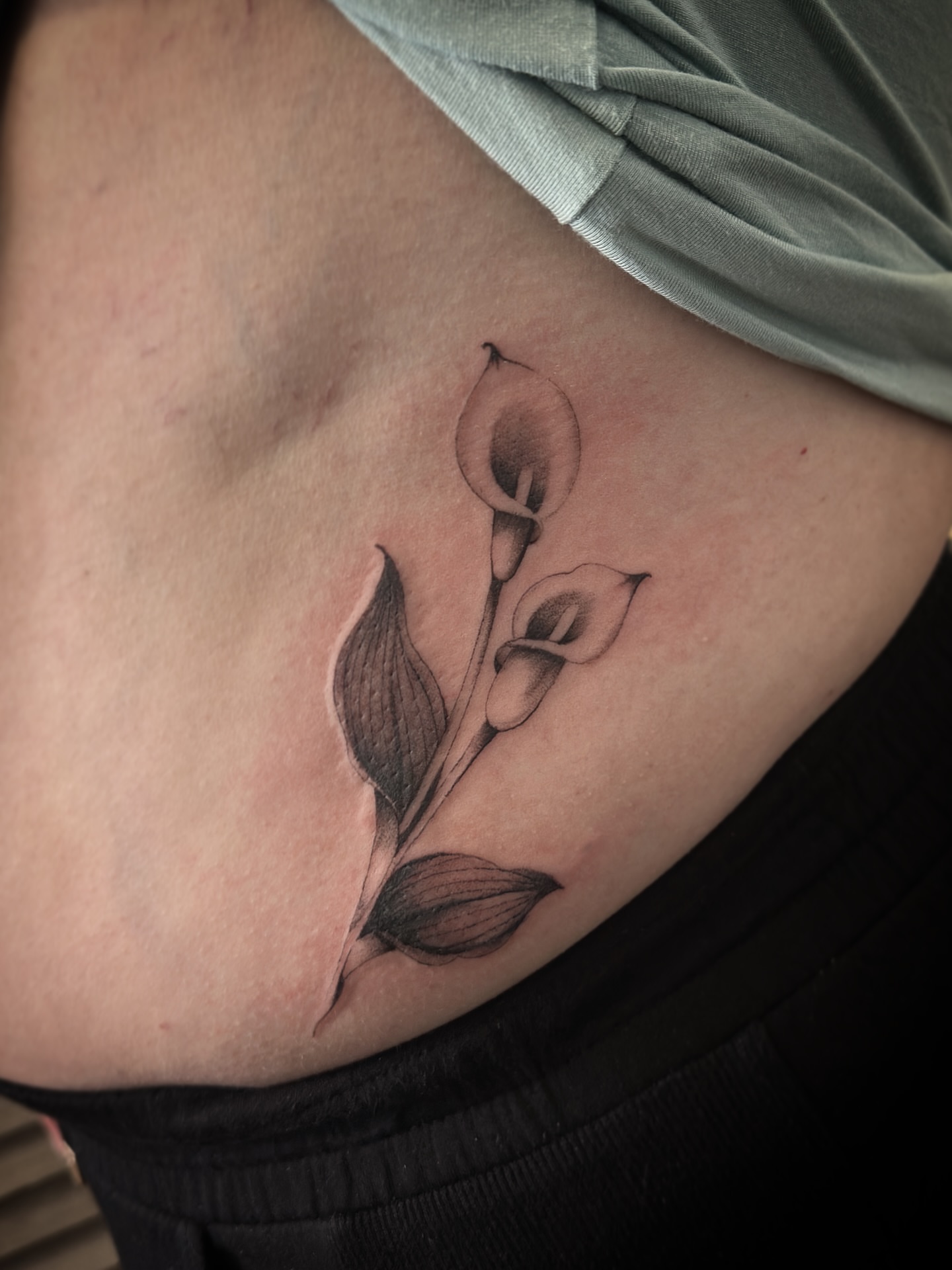 Calla lilies black and grey tattoo on the ribs by Matt Kearney