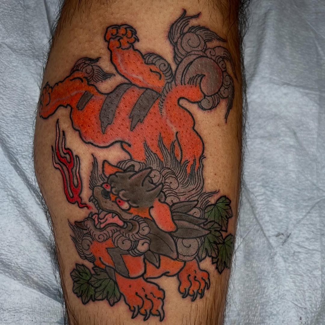 Lion dog and clouds American traditional tattoo on the thigh by Troy David Souders