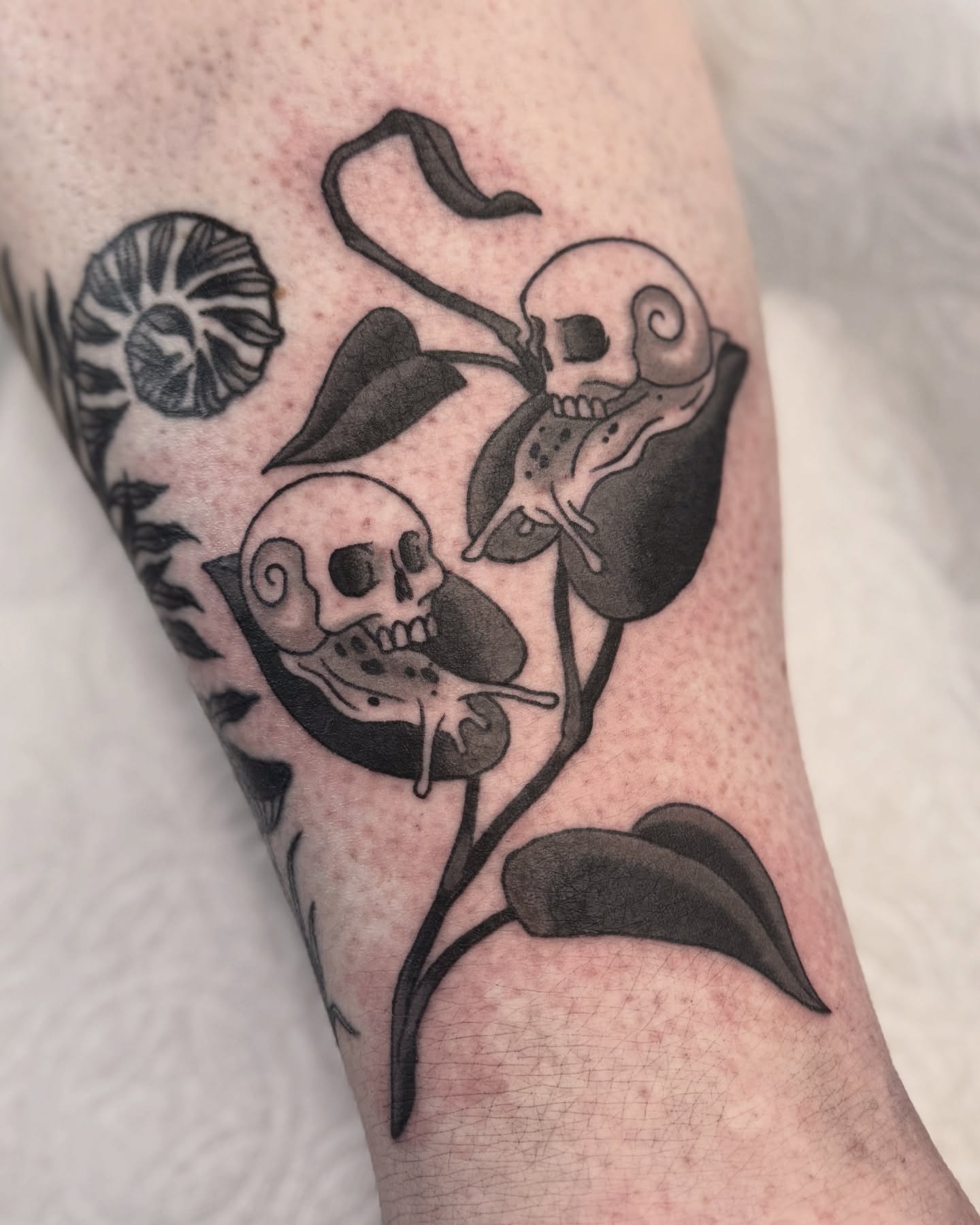 Skulls and calla lilies dark realism tattoo on the forearm by Nia (Knee-uhh) 🦷