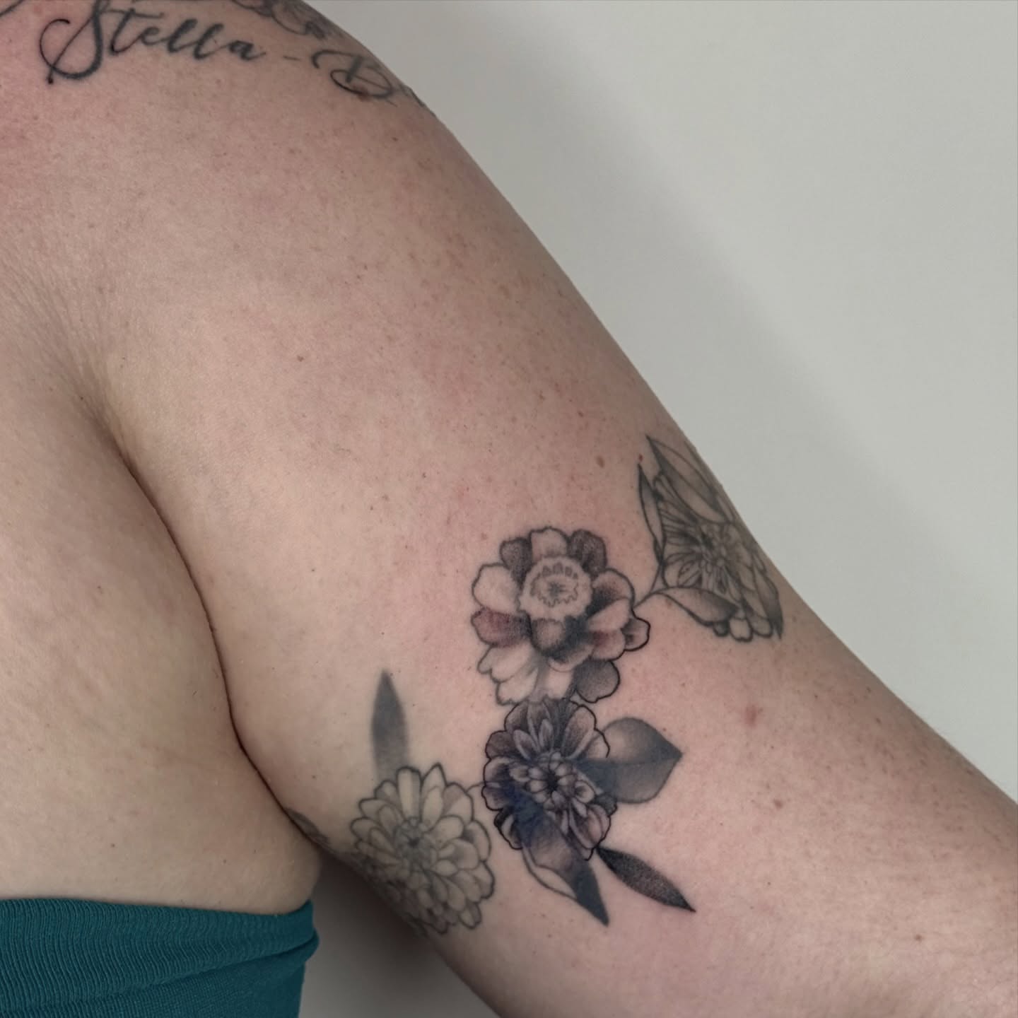 Flowers black and grey tattoo on the forearm by autumn sky