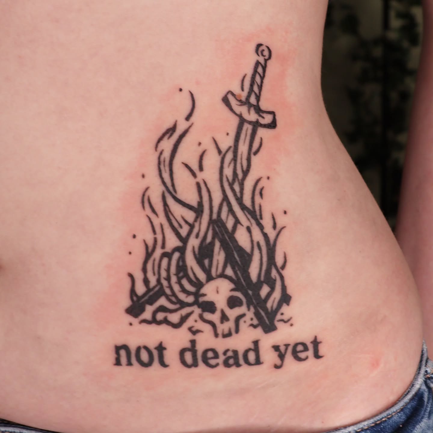 Sword and flames black and grey tattoo on the thigh by Veronika Lipchak