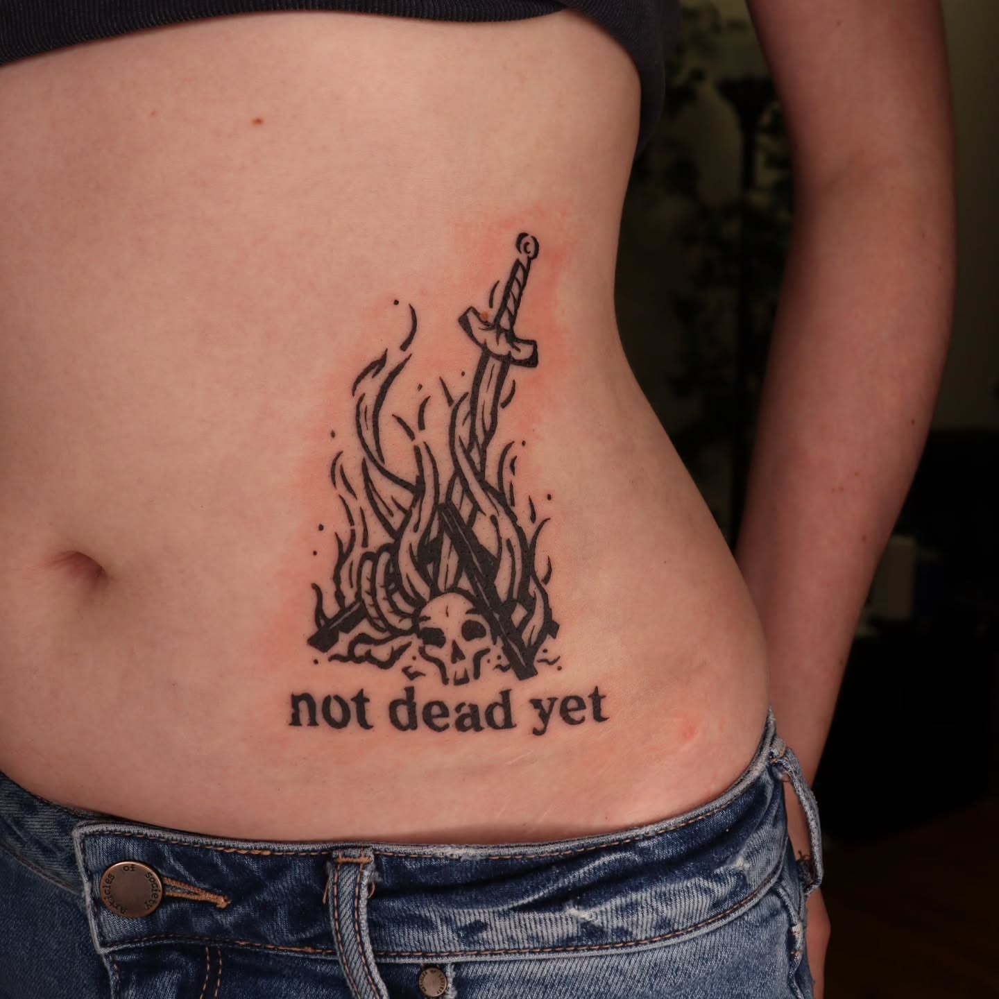 Sword and flames black and grey tattoo on the torso by Veronika Lipchak