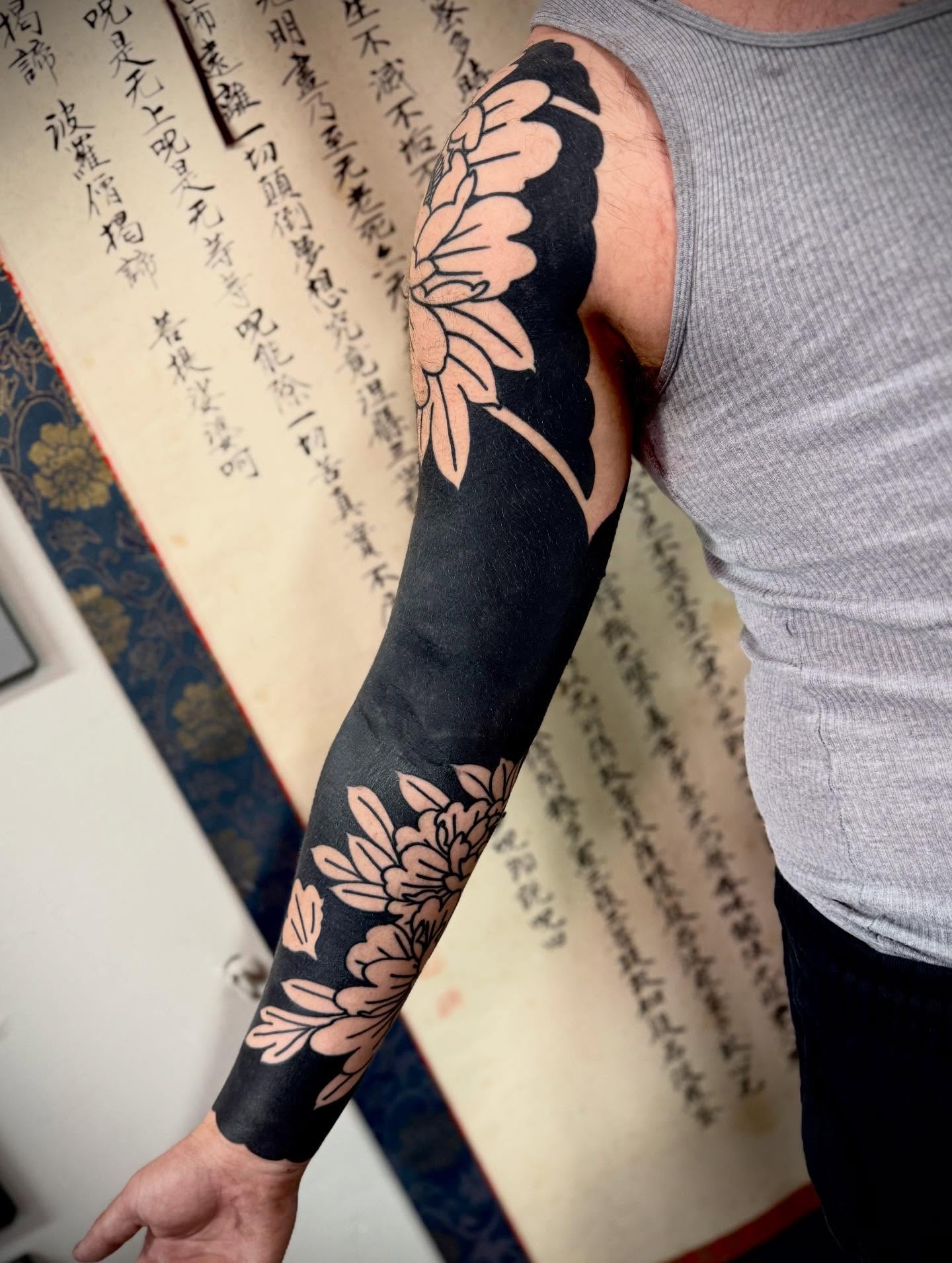 Chrysanthemum black and grey tattoo on the upper arm by Jason Eisenberg