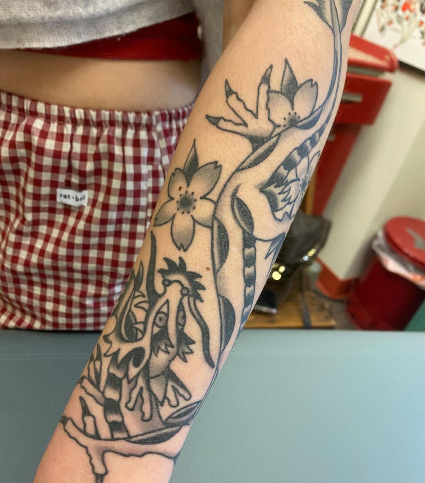 Dragon and flowers American traditional tattoo on the forearm by Abby Rose Estes