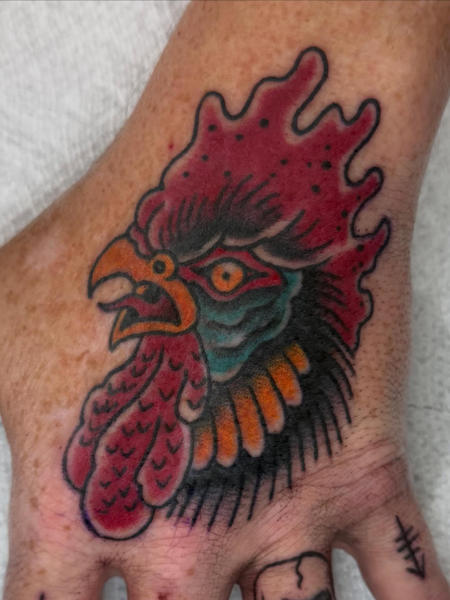 Rooster American traditional tattoo on the hand by Trent Parsley