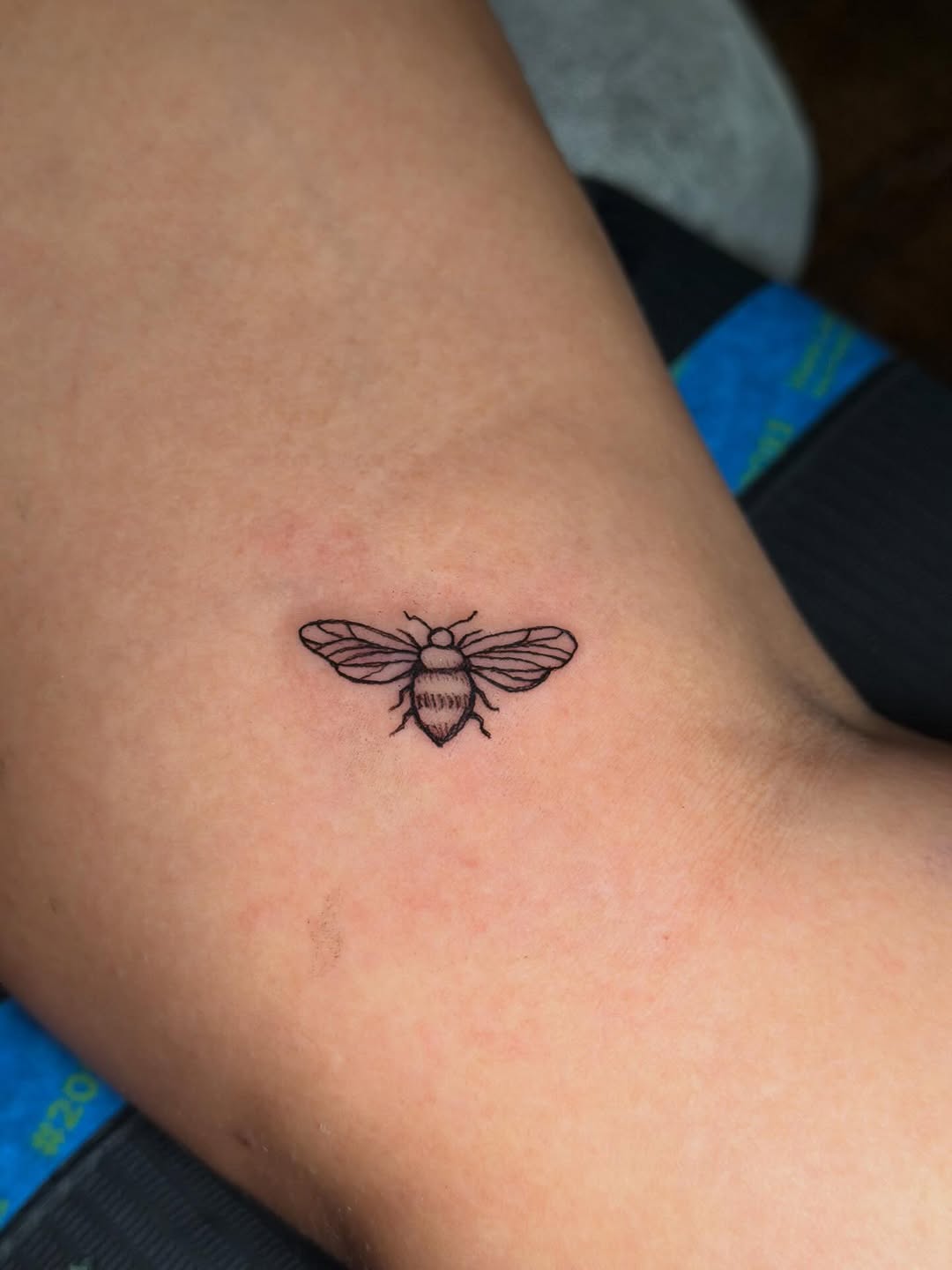 Bee fine line tattoo on the forearm by C.J.K. Roy
