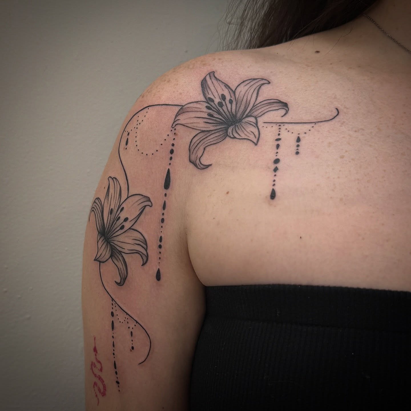 Lily dotwork tattoo on the shoulder by Lindsay Shriver