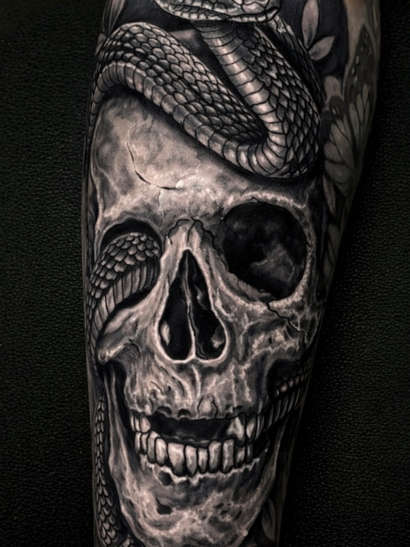 Skull with snake realism tattoo on the forearm by Gabriel Garcia