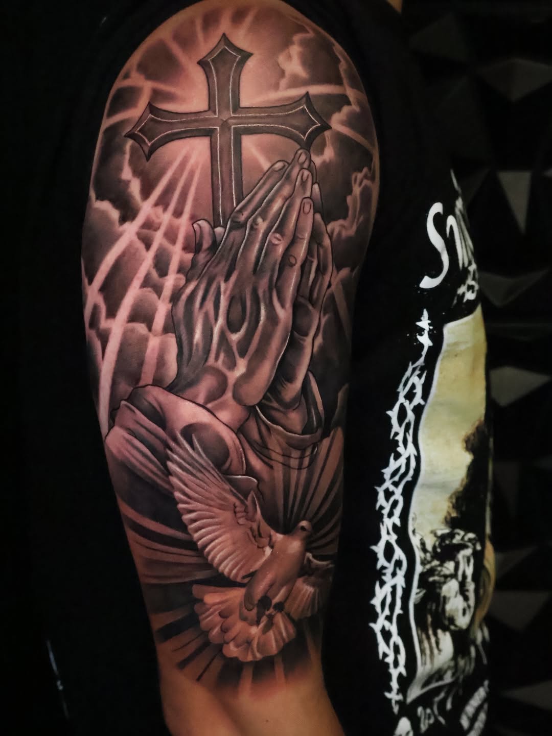 Praying hands with cross and dove Chicano tattoo on the forearm by Angels tattoo