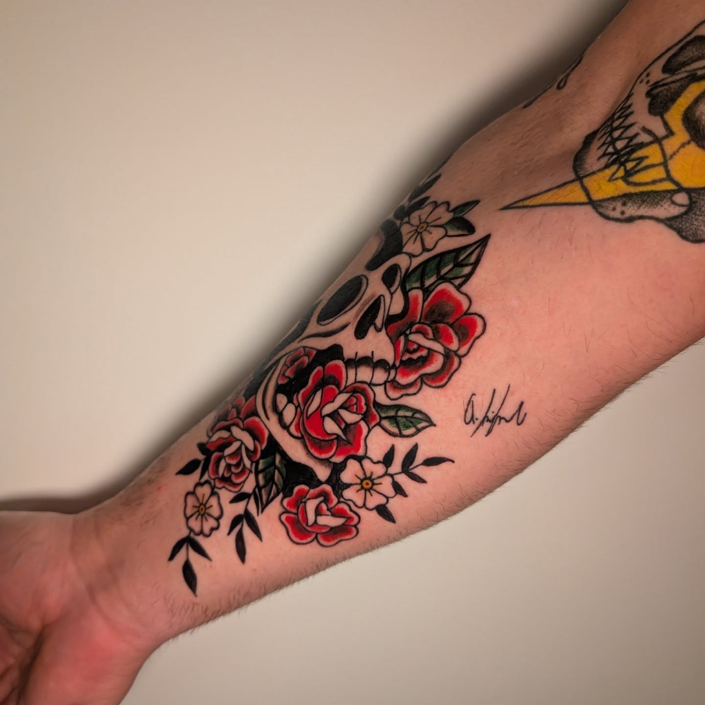 Skull and roses American traditional tattoo on the forearm by Arminda Walborn
