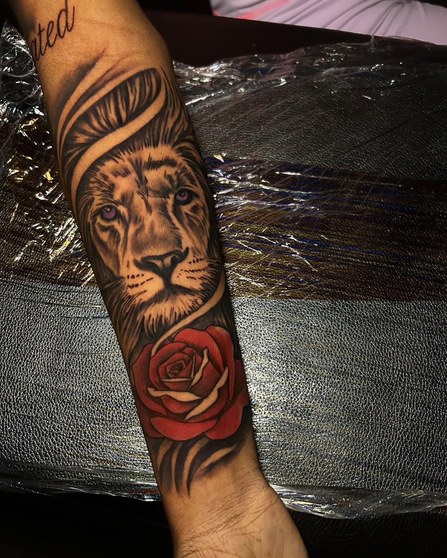 Lion and rose realism tattoo on the forearm by Ferlandis Fitch, Long Beach, California