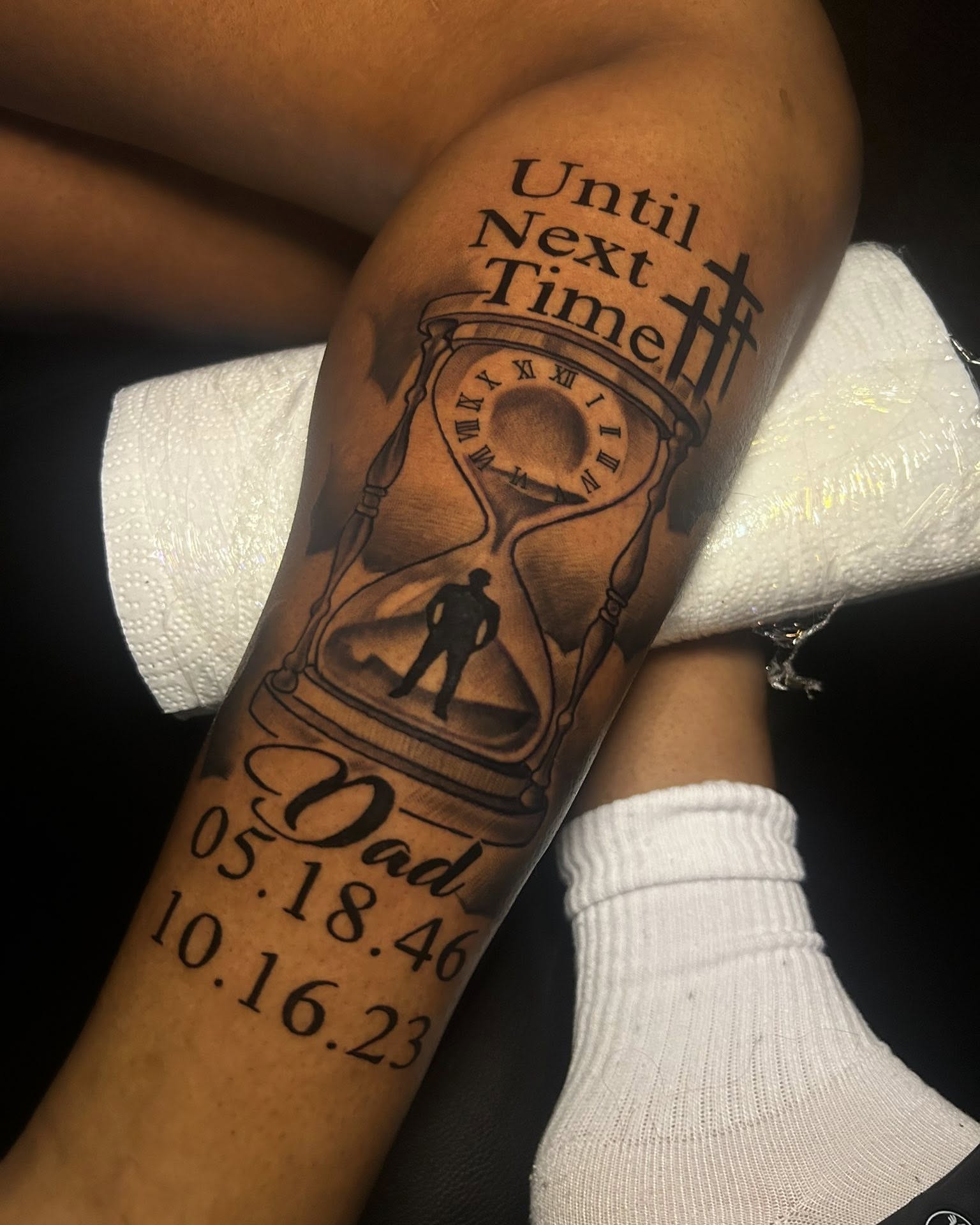 Hourglass with silhouette black and grey tattoo on the forearm by Ferlandis Fitch, Long Beach, California