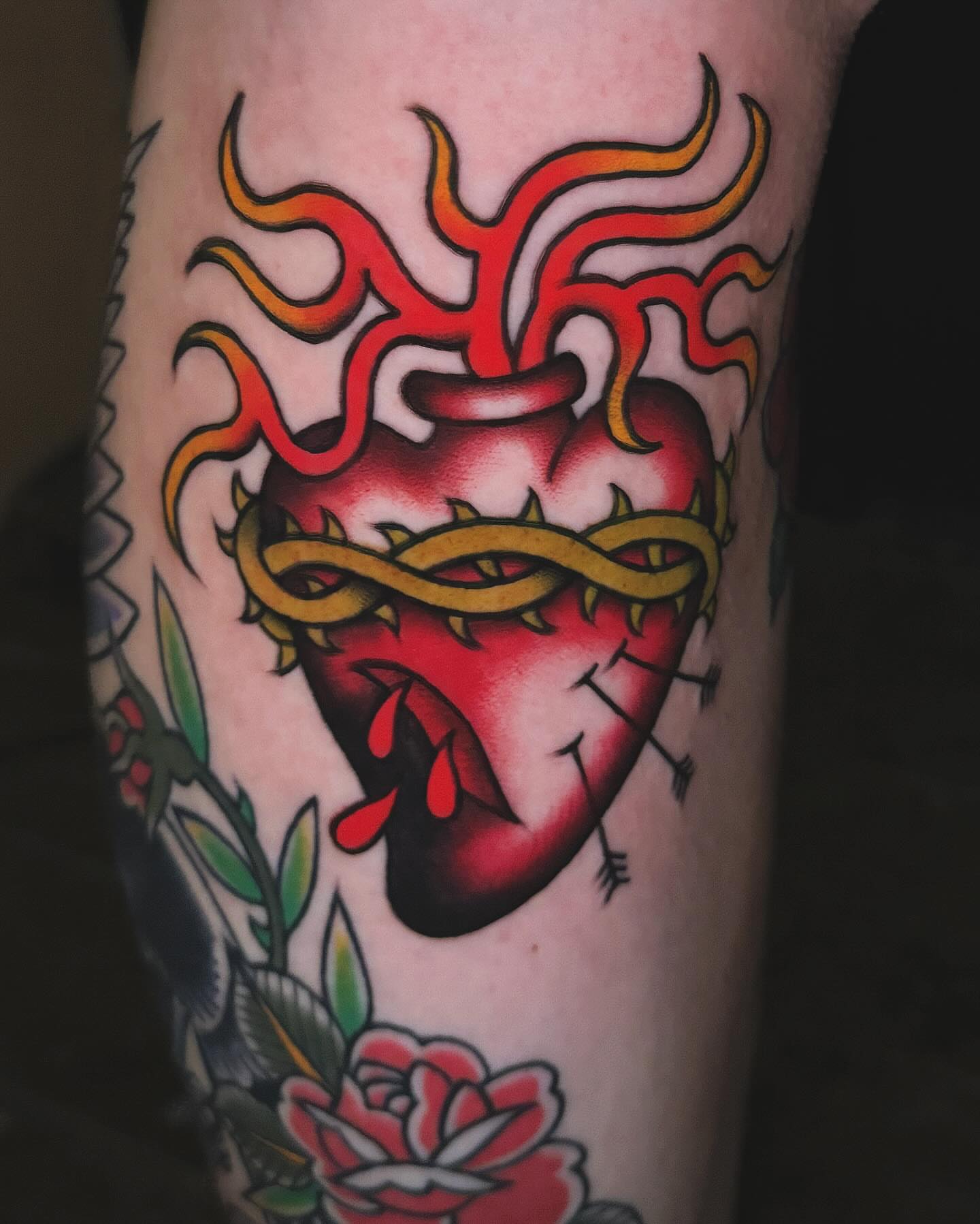 Heart with flames American traditional tattoo on the forearm by Nikki Bee