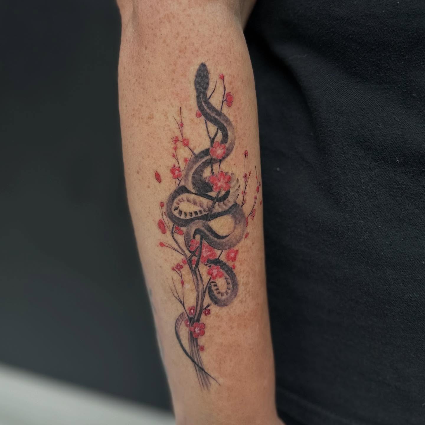 Snake and blossoms dotwork tattoo on the forearm by Vicious Marc