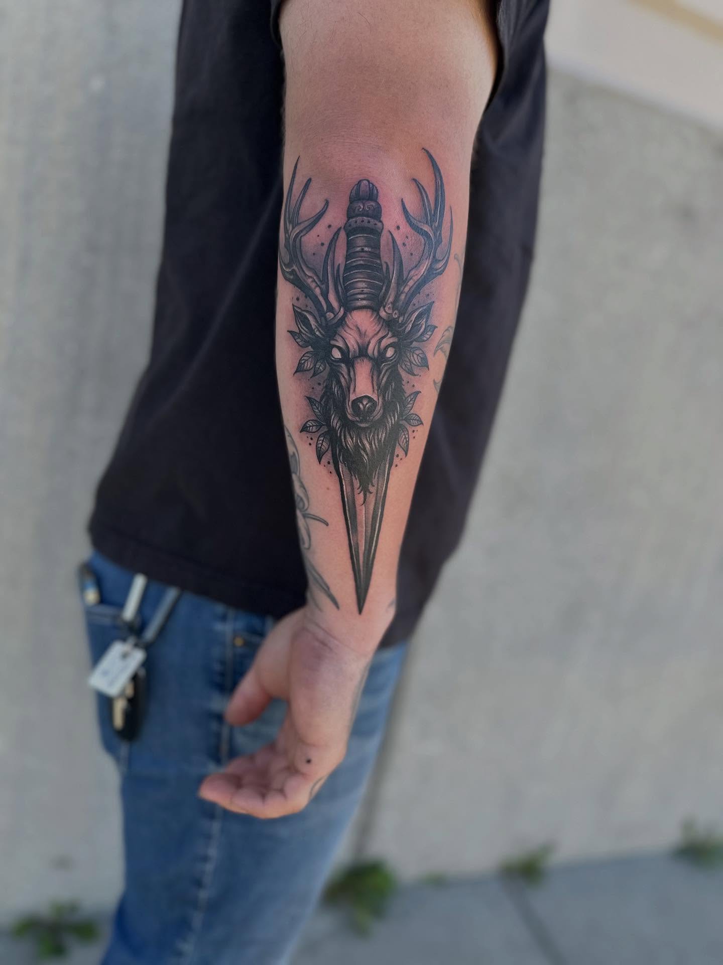 Stag head with dagger geometric tattoo on the forearm by Ruben