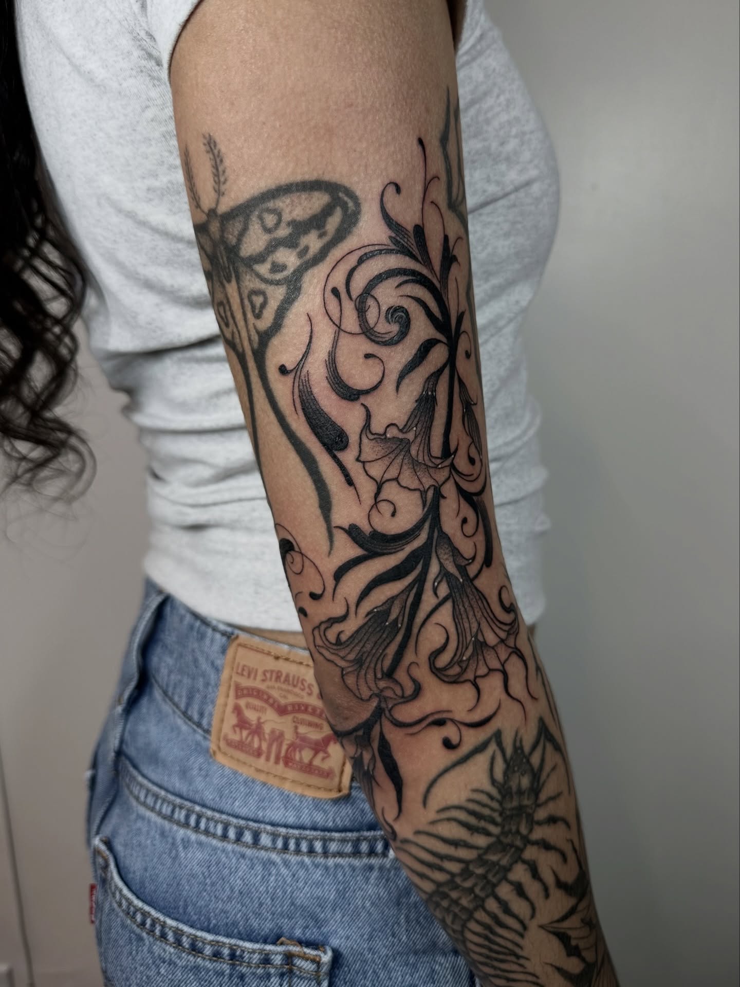 Floral and abstract ornamental tattoo on the forearm by Brooklyn Bailey