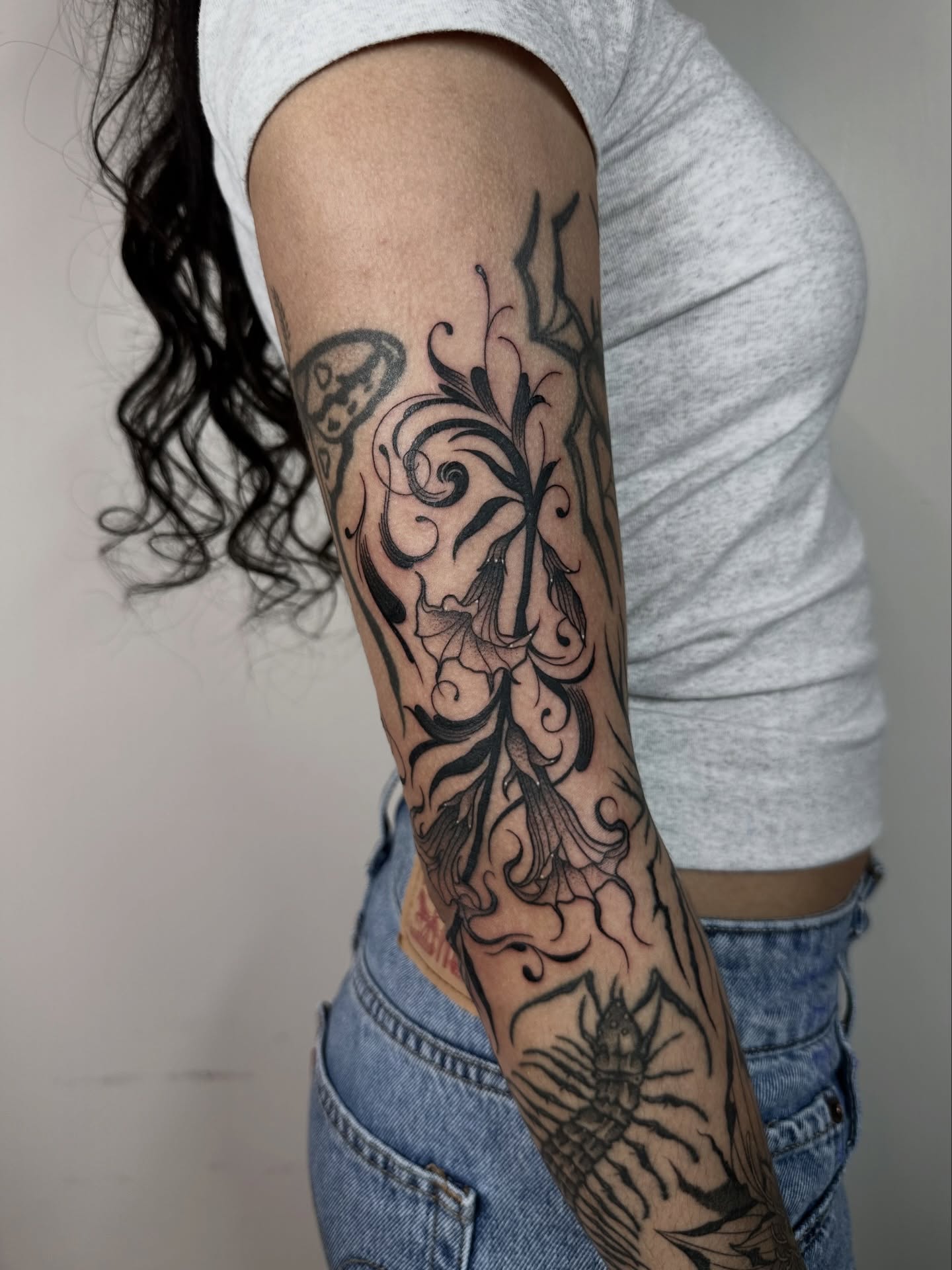 Floral design black and grey tattoo on the forearm by Brooklyn Bailey