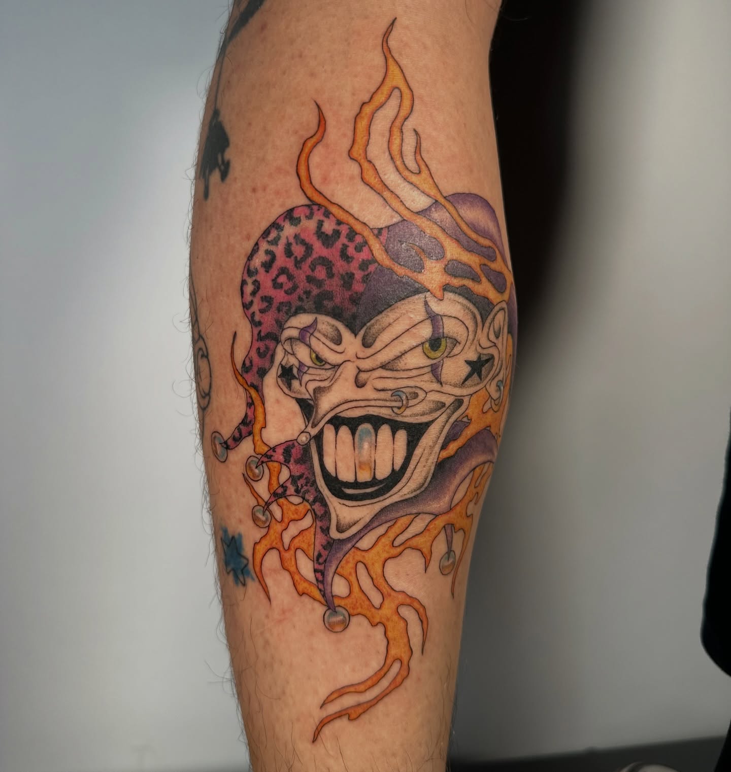 Joker-like face American traditional tattoo on the forearm by sechi