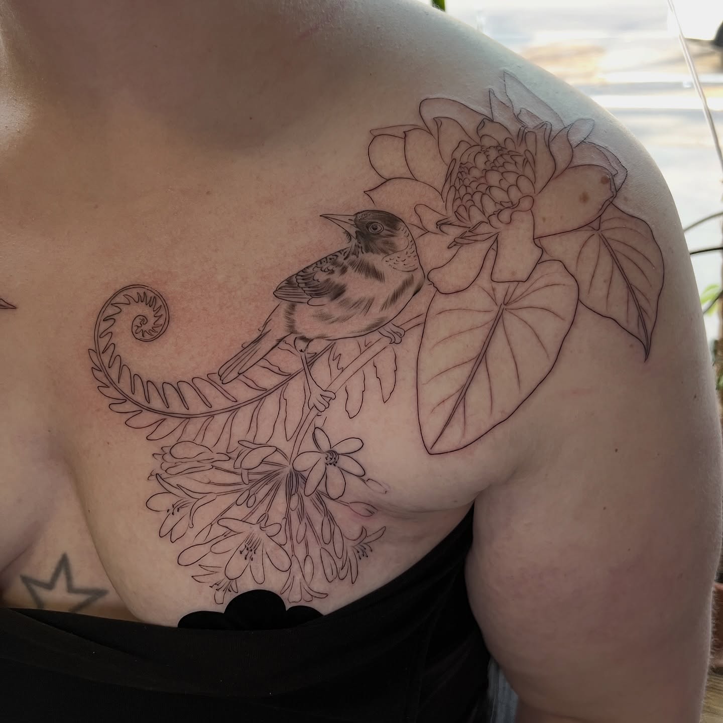 Bird and floral arrangement realism tattoo on the chest by Jen Rahman