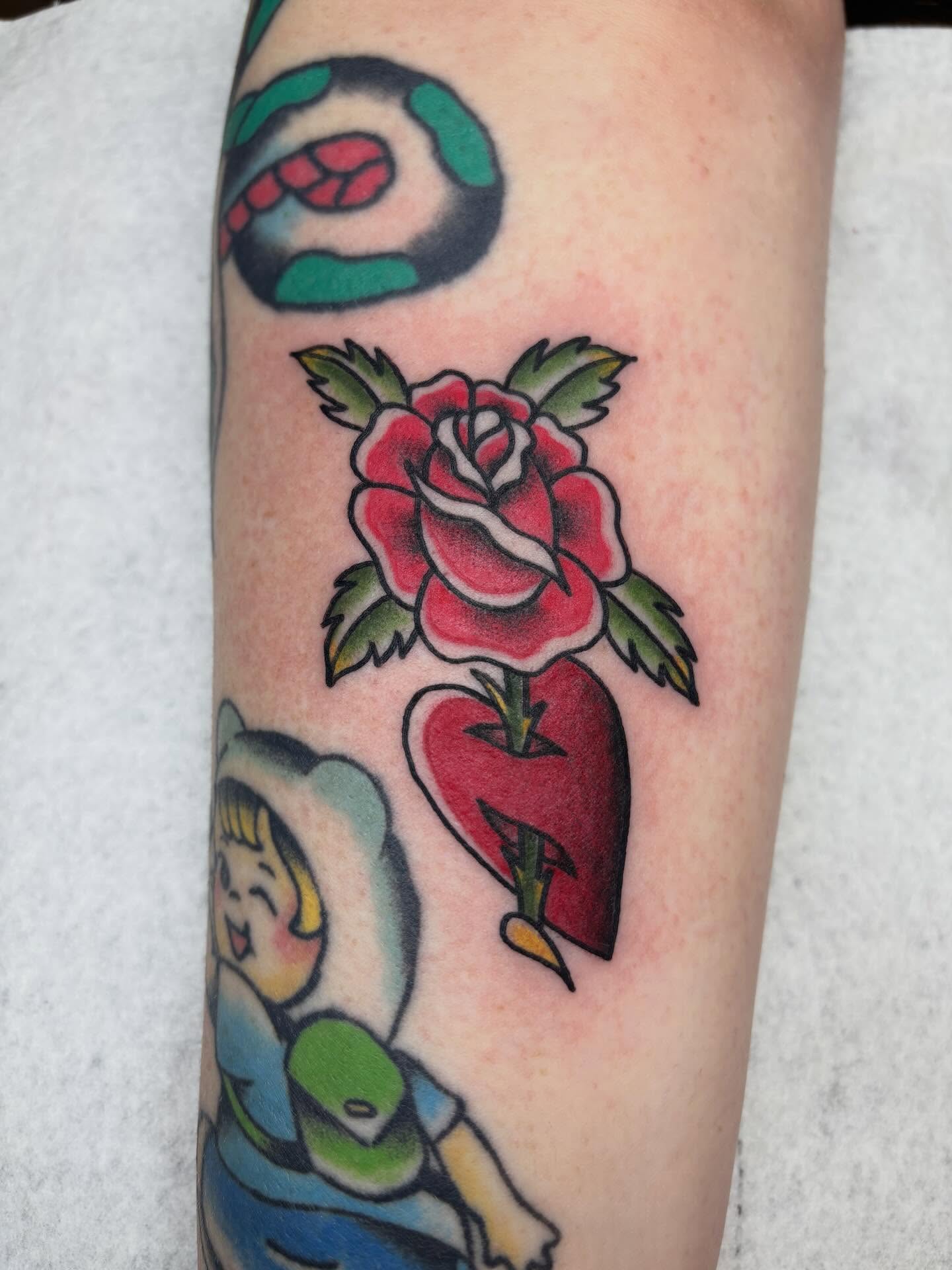 Rose and heart American traditional tattoo on the forearm by Malia Clark