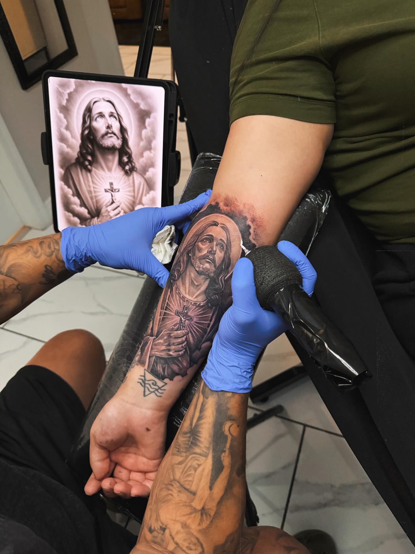 Religious figure realism tattoo on the forearm by Adrian gonzalez...