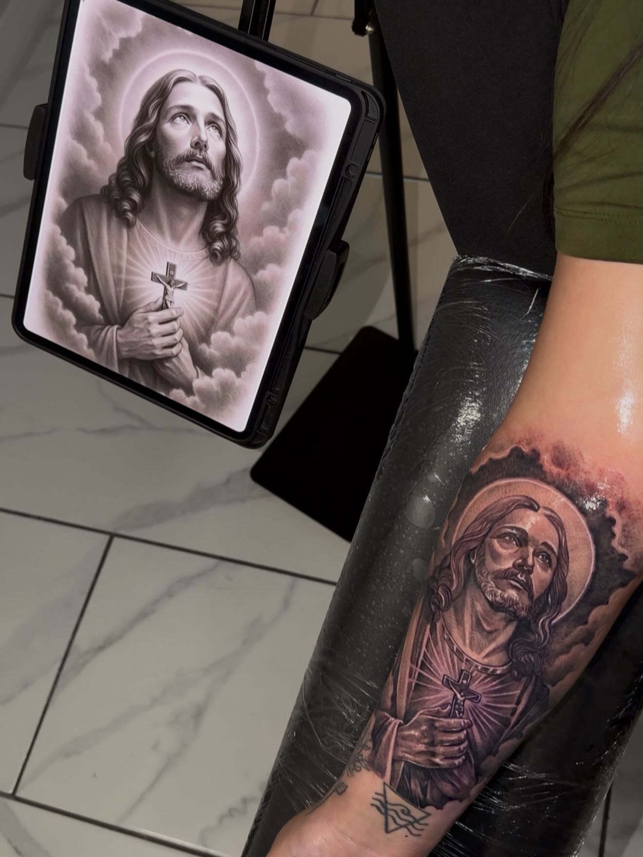 Religious figure black and grey tattoo on the forearm by Adrian gonzalez...