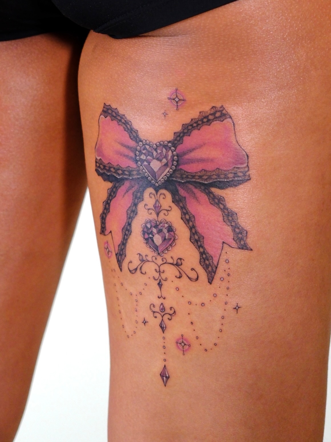 Bow and hearts ornamental tattoo on the thigh by ââŪ. Ý ðķðð―ððð âðĶđËâ seattle tattoo artist, Seattle, Washington