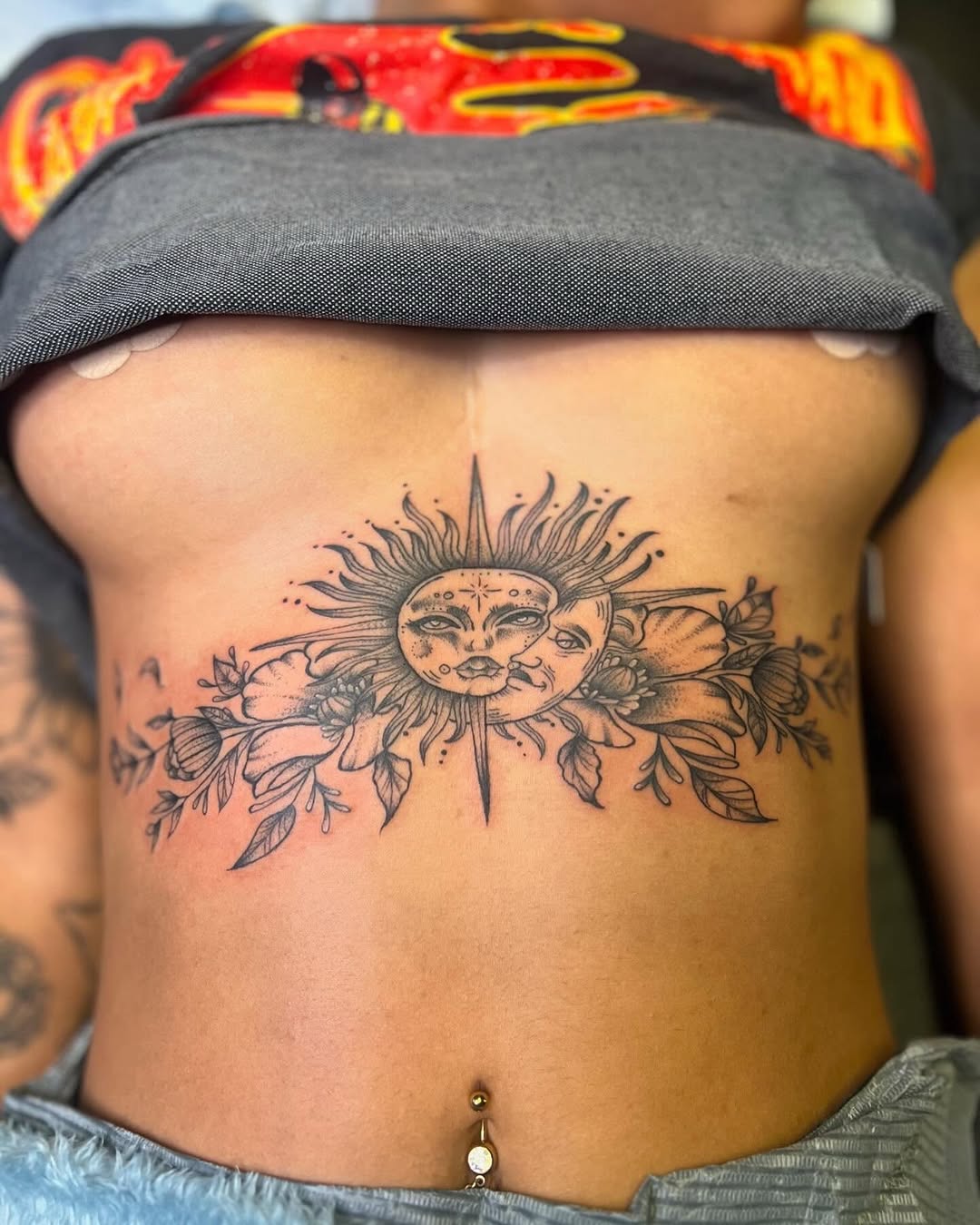 Sun and moon with floral elements ornamental tattoo on the ribs by Jazz Walker