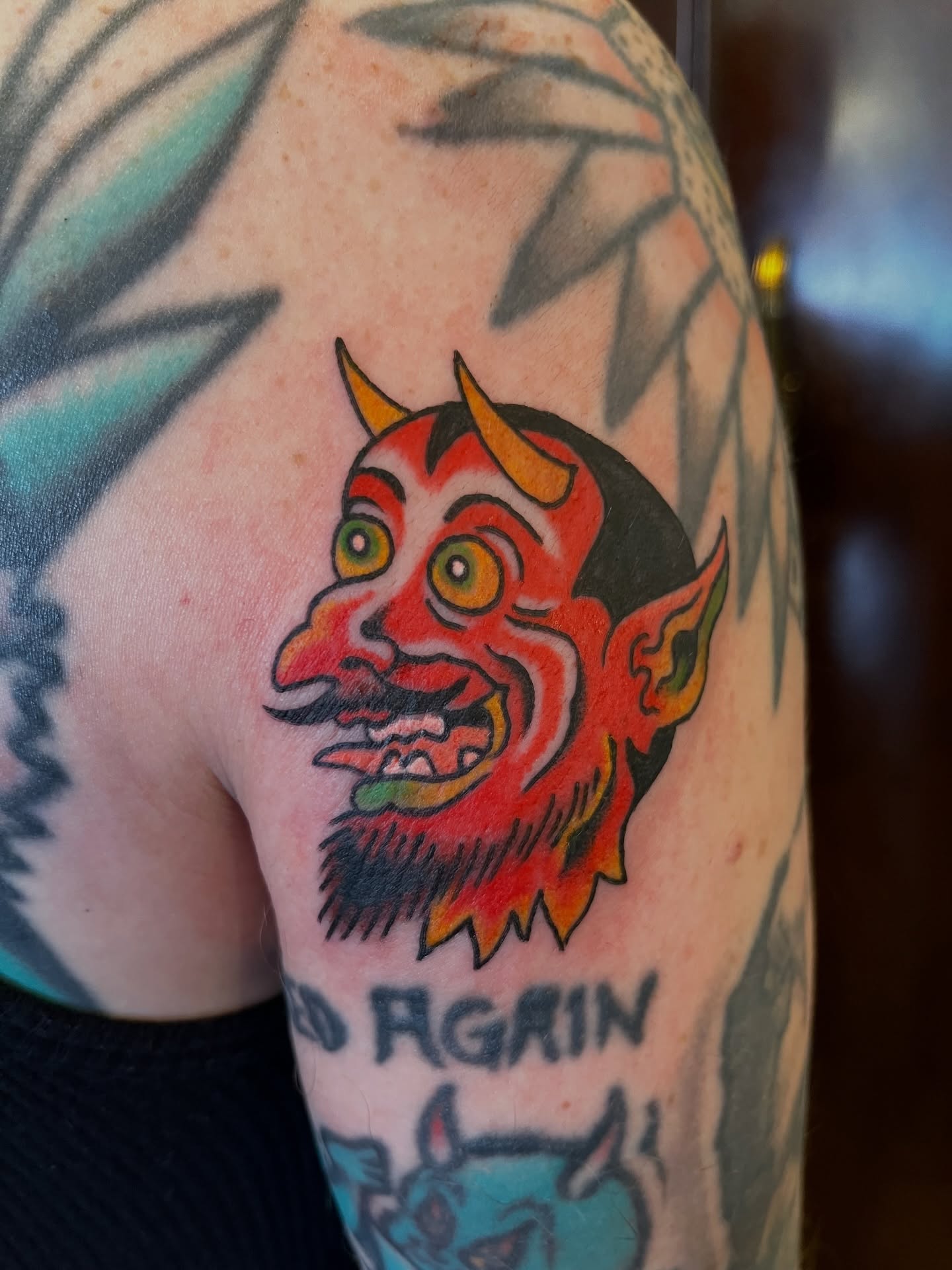 Demon head American traditional tattoo on the upper arm by Campbell Zane Alexander