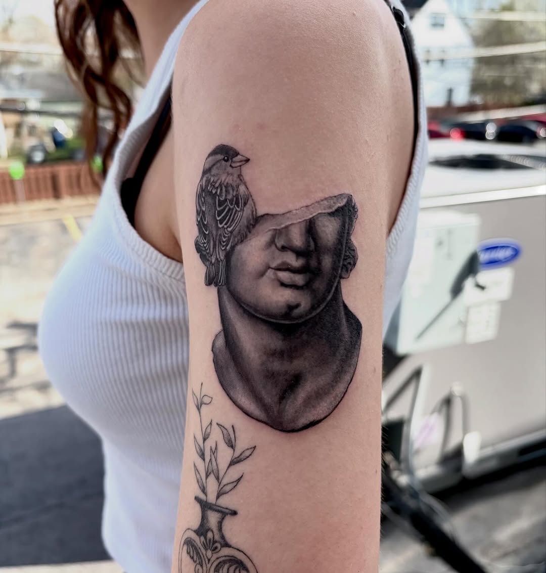 Statue bust with bird surrealism tattoo on the forearm by Marie Novotny, Lakewood, Ohio