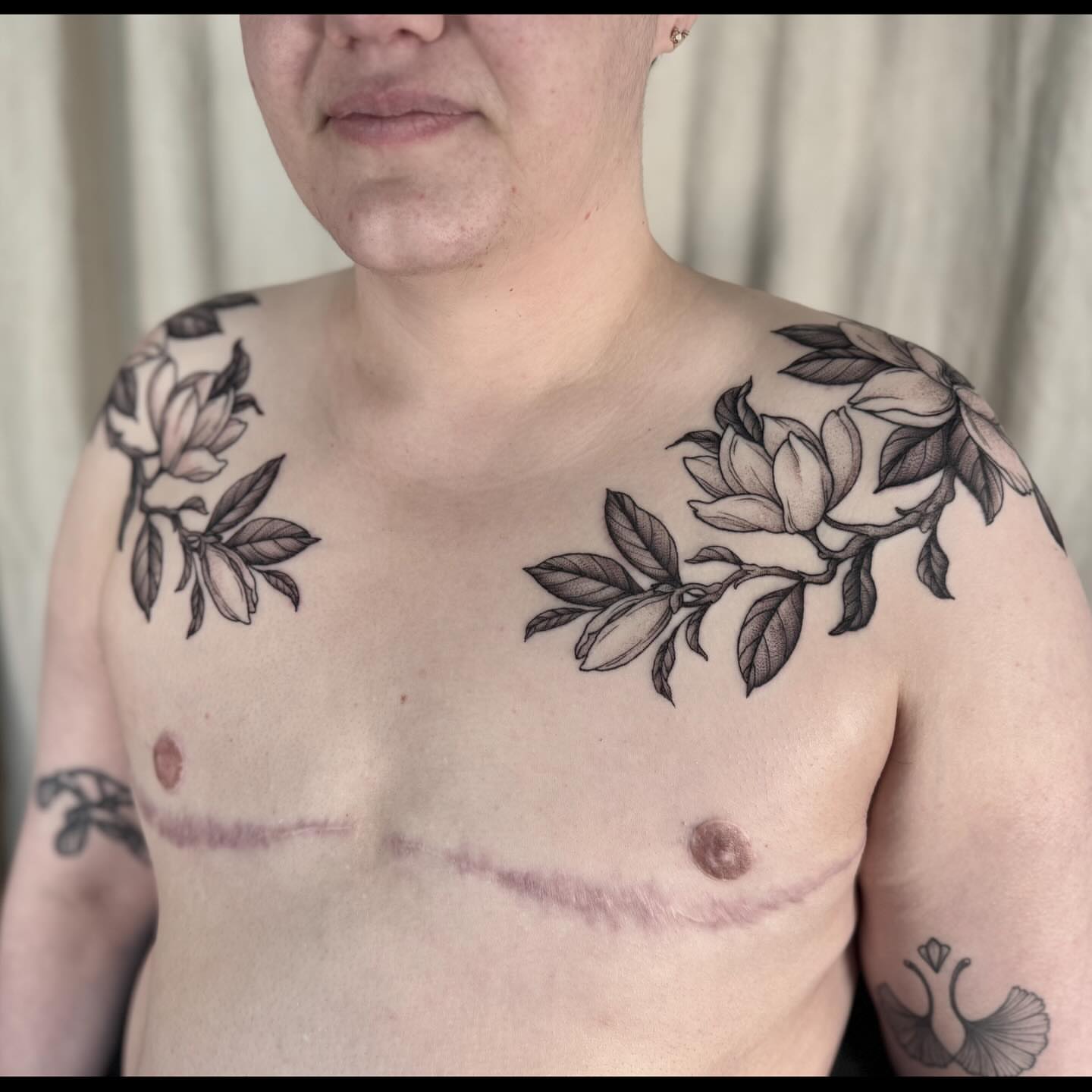 Magnolia flowers black and grey tattoo on the chest by Hillary