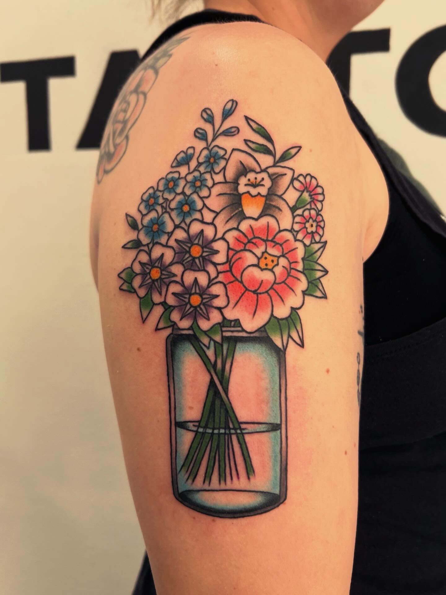 Flower bouquet American traditional tattoo on the upper arm by Samantha Citer